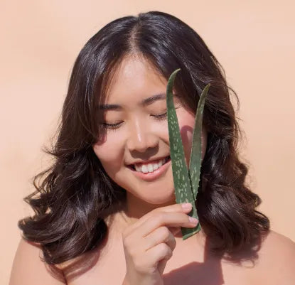 mulher morena com folhas de aloe vera na mão