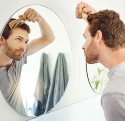 Homem a pentear o cabelo na frente de um espelho redondo
