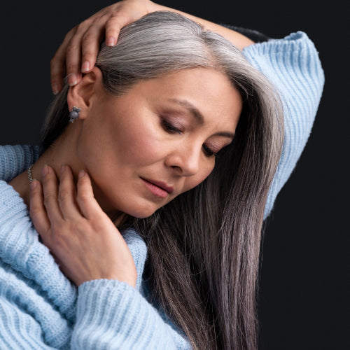 Mulher toca nos fios do cabelo branco cuidado.