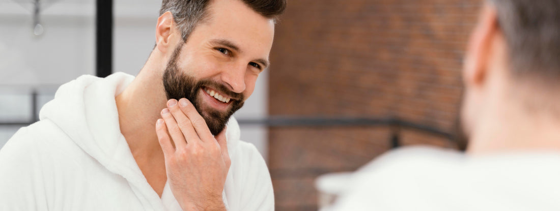 Homem sorri em frente ao espelho, ponderando se pode pintar a barba.