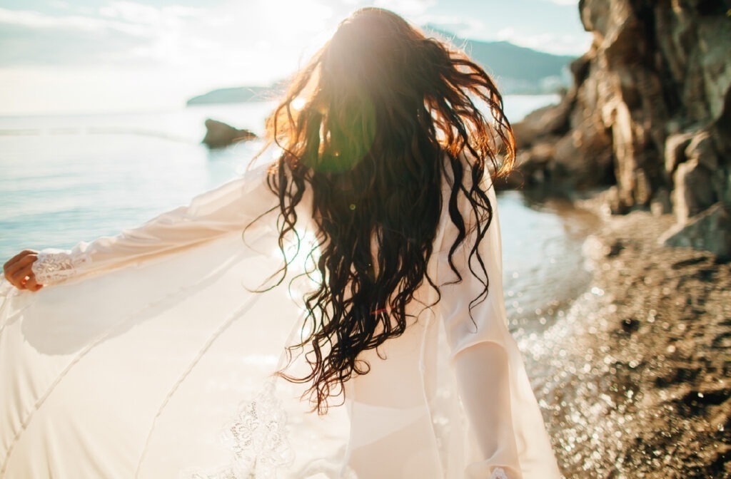 jovem-mulher-a-passear-na-praia-com-o-cabelo-solto-tratado