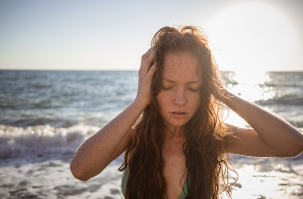 jovem com cabelo molhado na praia