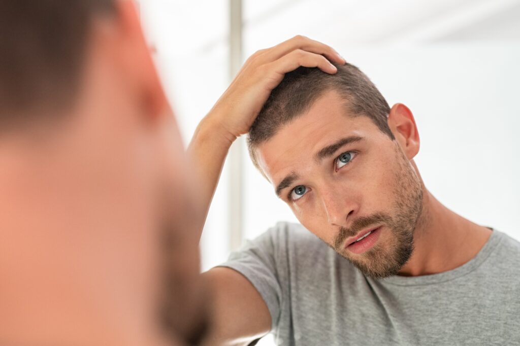 Jovem verificando o cabelo no espelho